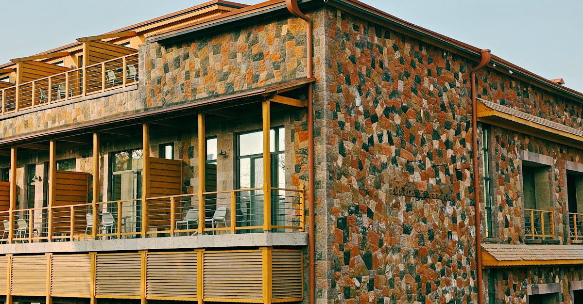 Photo by Doctor Unface Modern building with a rustic stone facade and wooden elements, under a clear blue sky.