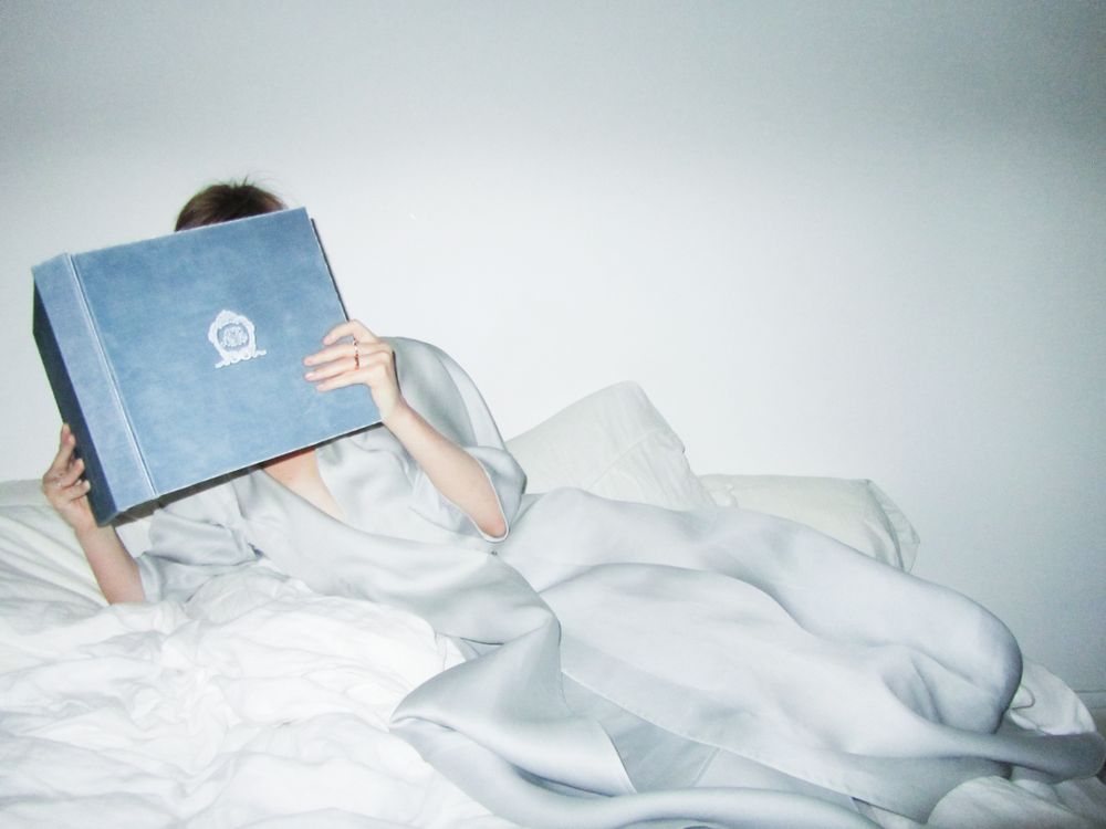 The Reading Robe Person in Satin Robe Reading a Book in Bed · Free Stock Photo