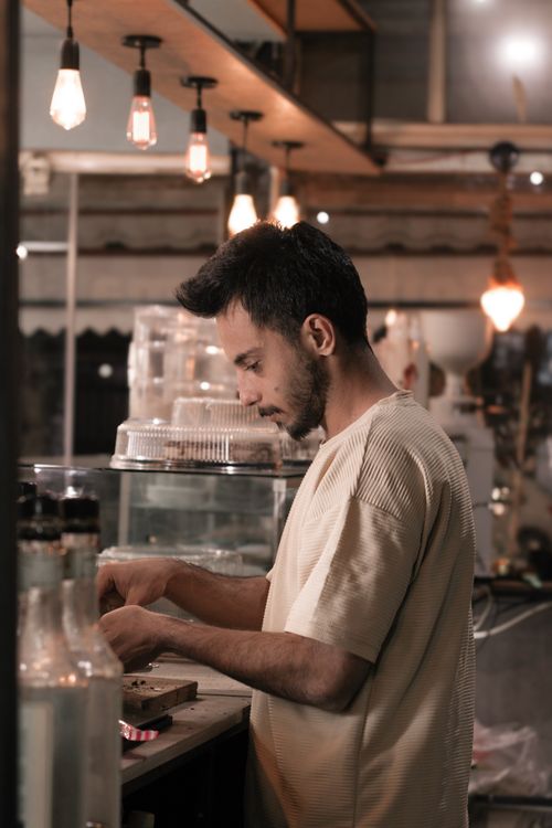 Free A barista prepares beverages in a warm-lit cafe in Kermanshah, Iran. Stock Photo
