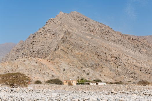 Discover the rugged beauty of Ras Al Khaimah's rocky mountain landscape under a clear blue sky.