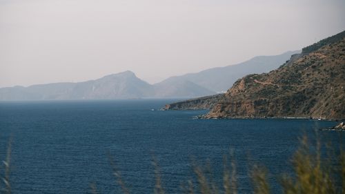 Free Breathtaking view of rugged cliffs meeting the blue sea on a hazy day. Stock Photo