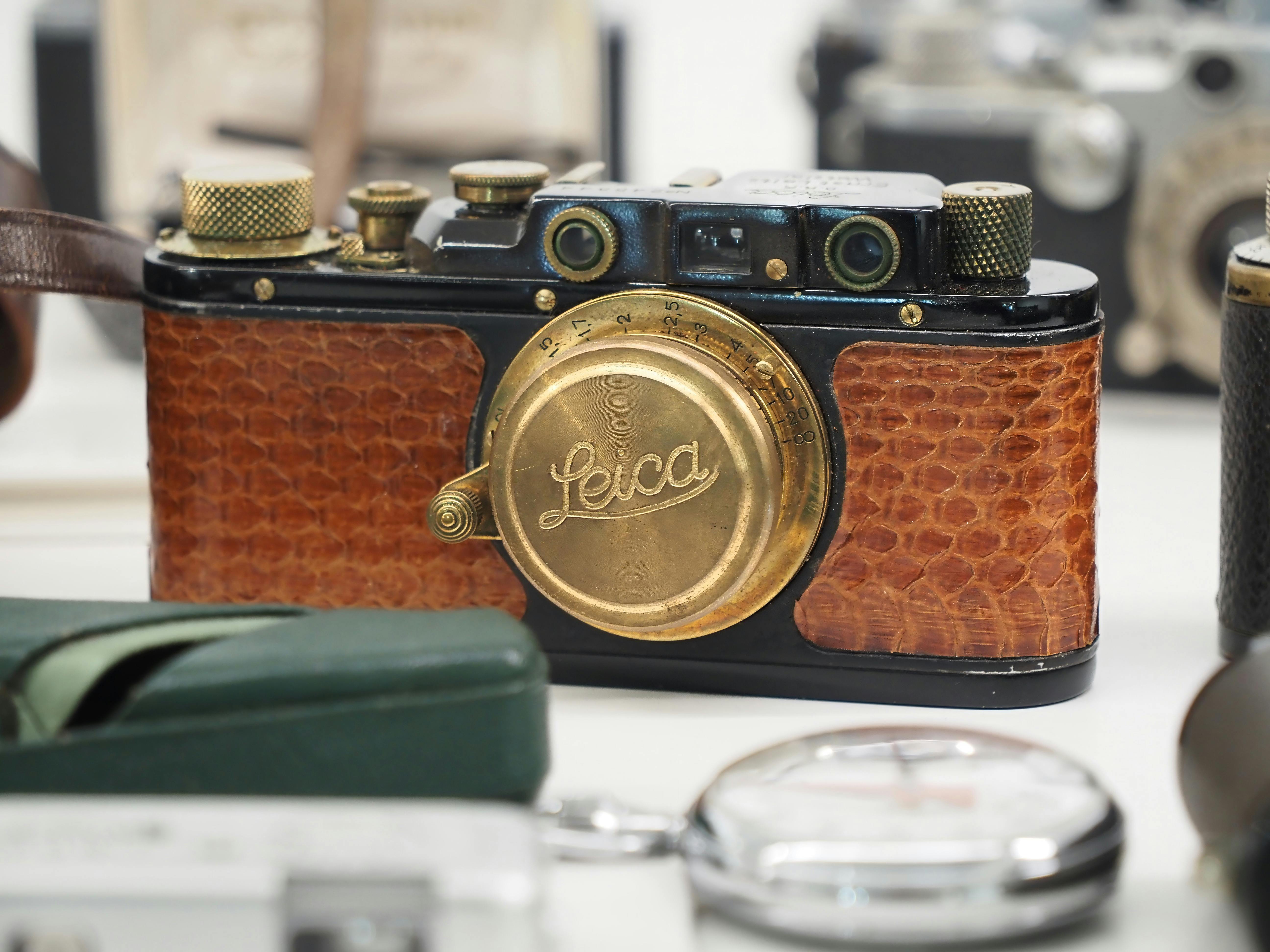 Close-up of a vintage camera with a brass cap and leather covering.