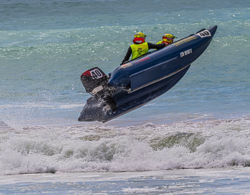 Free Thrilling moment of a powerboat catching air during a high-speed ocean race. Stock Photo