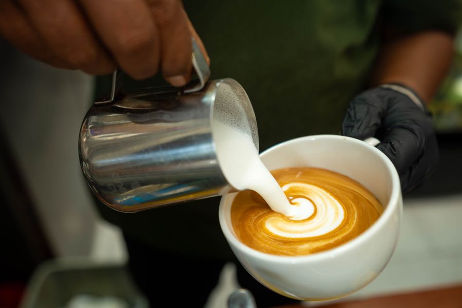 Üzerinde latte art deseni olan sütlü kahve — ÇİBADA flat white