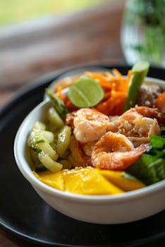 Delicious shrimp bowl with fresh vegetables, mango, and lime for a vibrant meal.