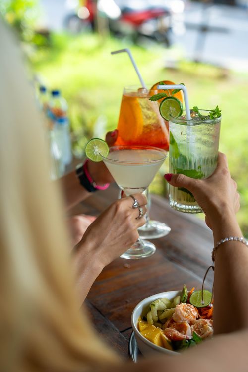 Free Three refreshing cocktails and a fresh salad served outdoors, ideal for a summer gathering. Stock Photo