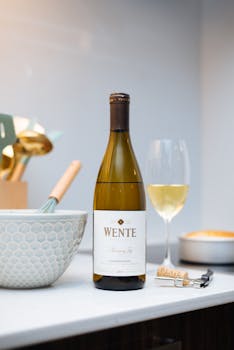 Chardonnay wine bottle with glass in a modern kitchen setting. Perfect for culinary stock use.