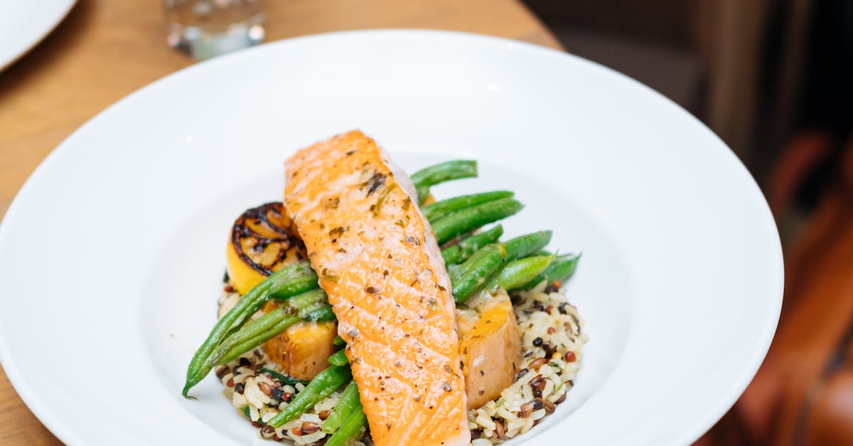 Photo by Mister Mister Grilled salmon served with quinoa, asparagus, and squash on a round table setting.