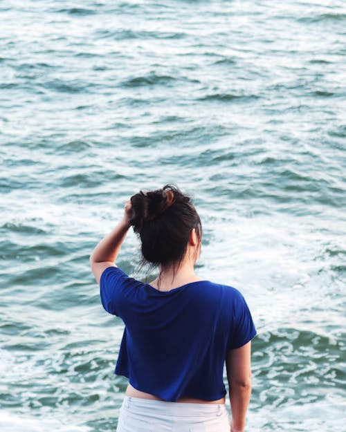 Woman in Blue Shirt Standing Near Body of Water