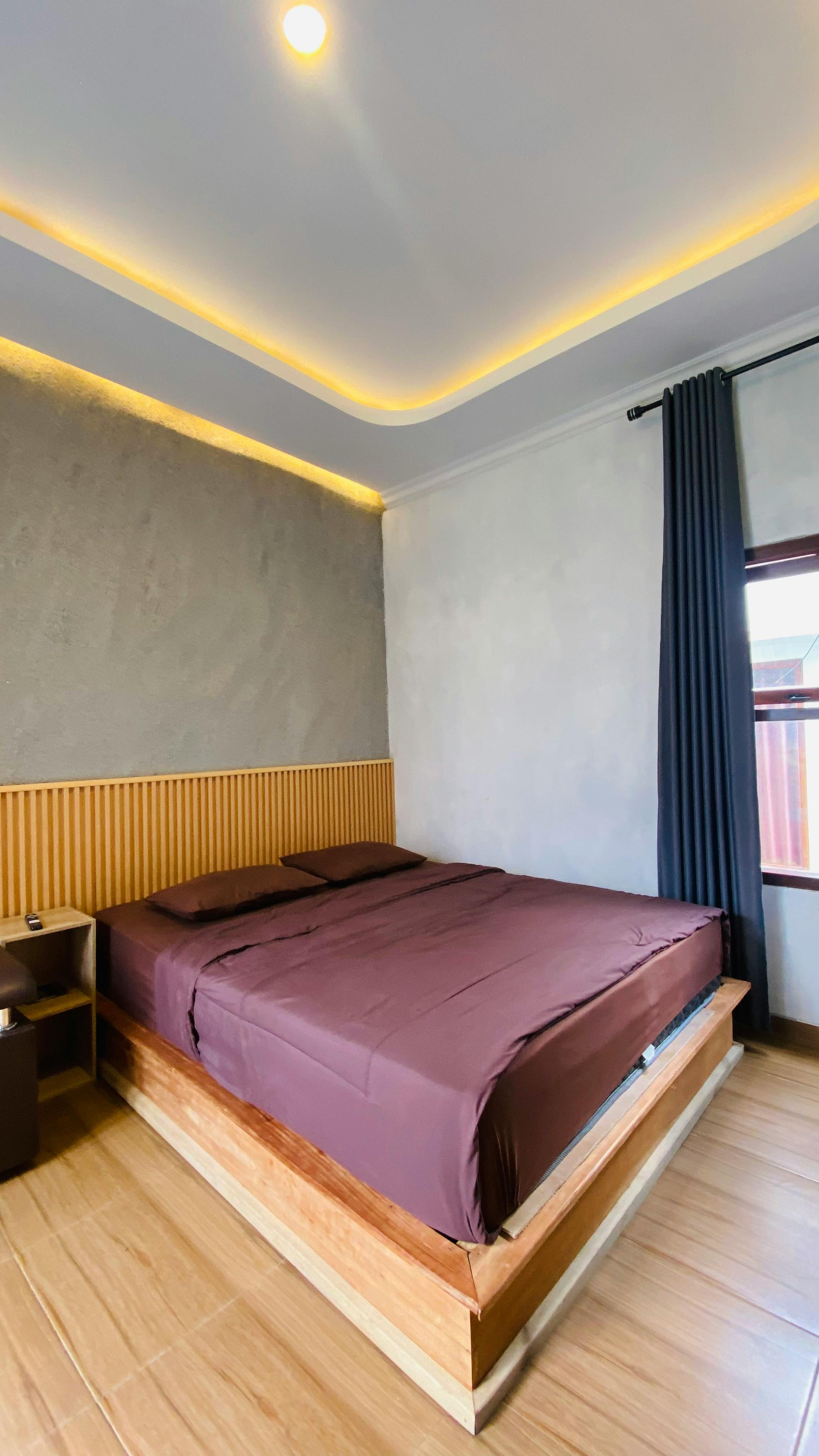 A stylish minimalist bedroom featuring a double bed and subtle lighting.