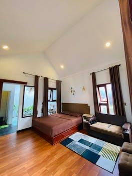 Spacious modern bedroom with brown decor and ample natural light, perfect for relaxation.