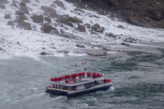 Tourist boat with passengers near the rapids of Niagara Falls, Canada.