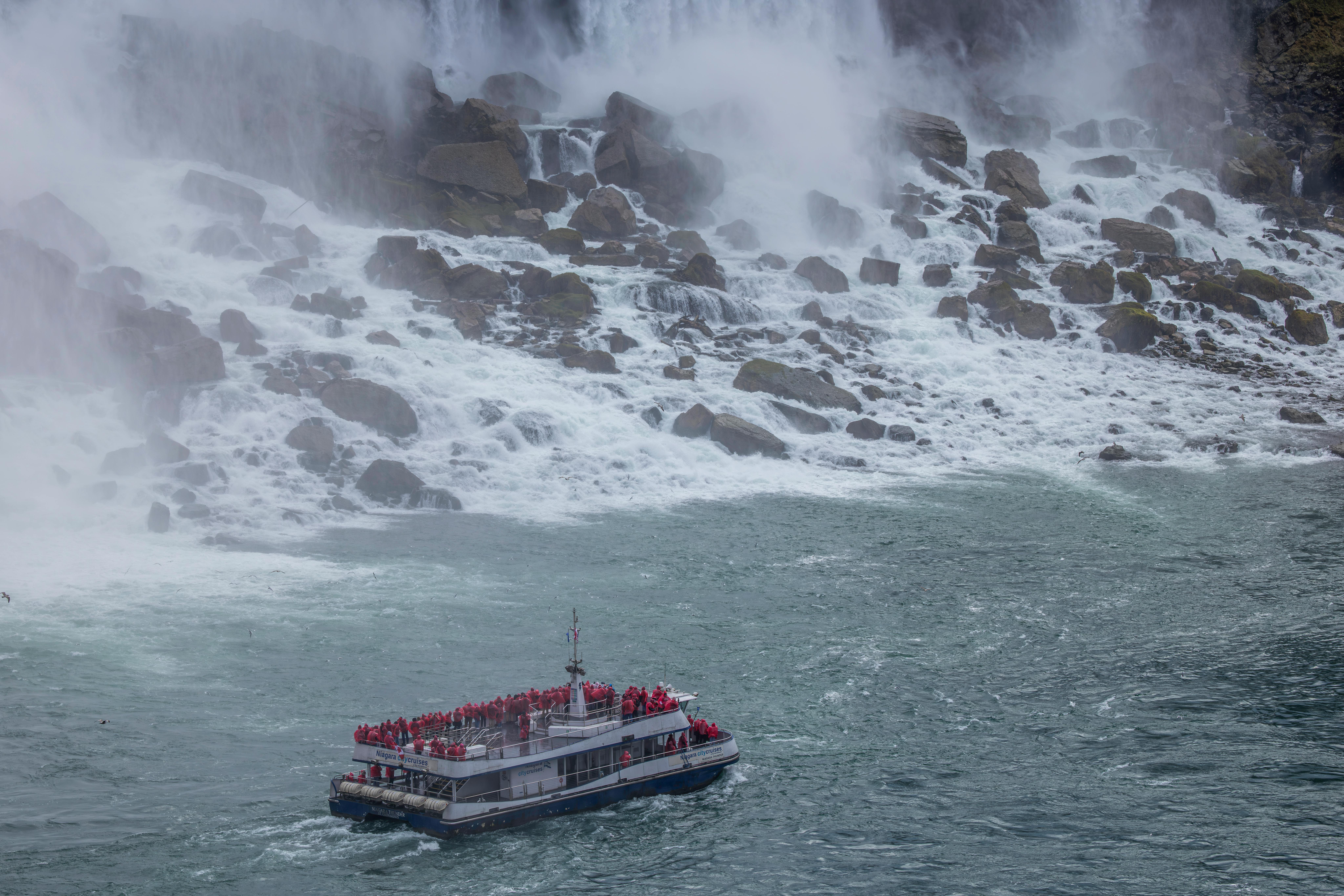 tour boat approaching powerful waterfall at niagara falls