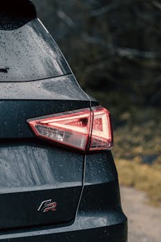 A detailed view of a car tail light on a rainy day in Manchester. Moody and atmospheric scene.