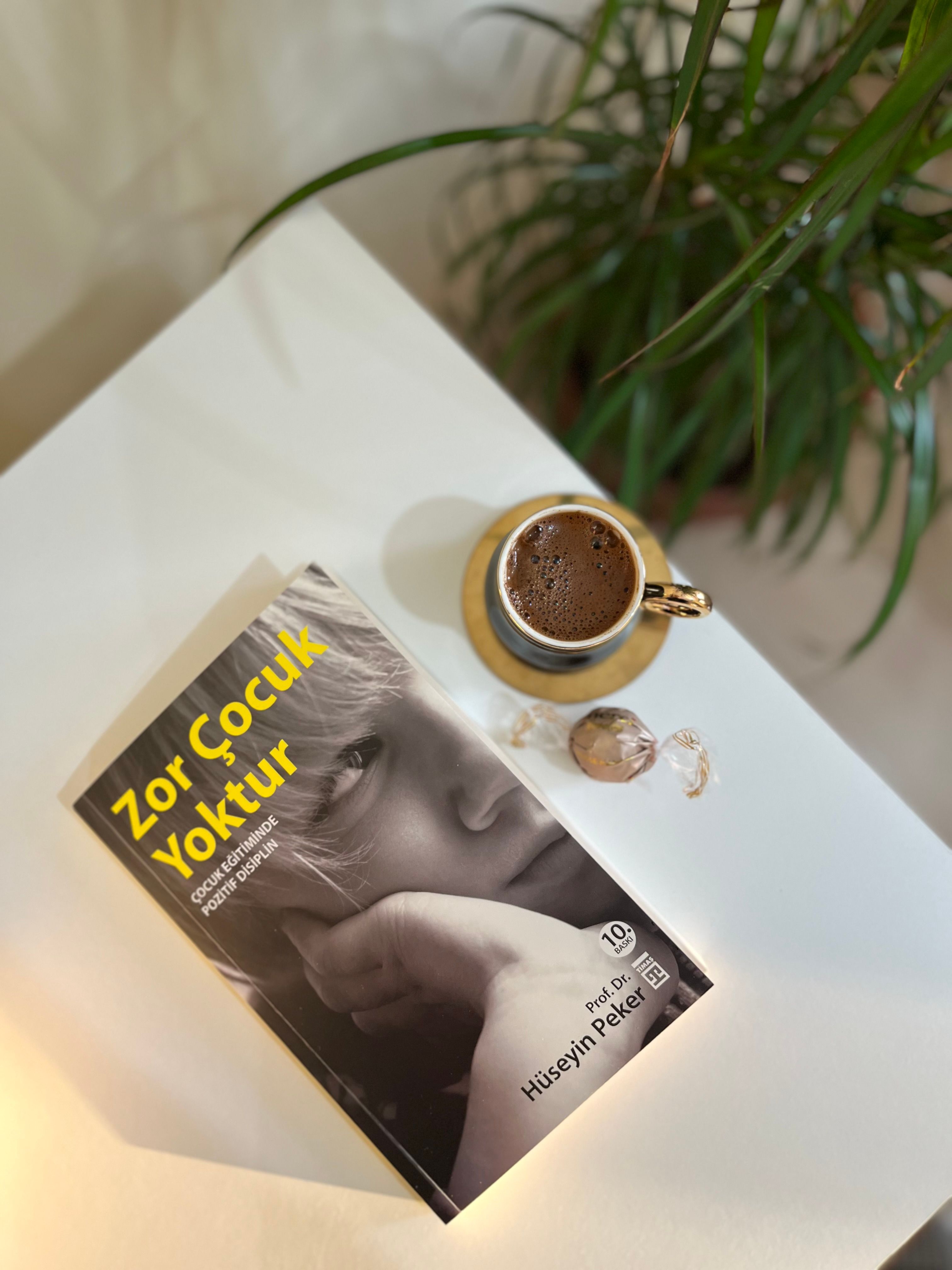 Top view of a book and coffee on a minimalist table, creating a cozy reading ambiance.