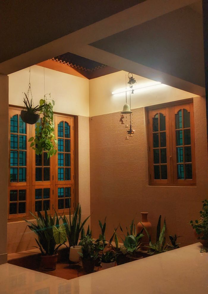 Rincón con plantas colgantes iluminado con luz cálida al anochecer