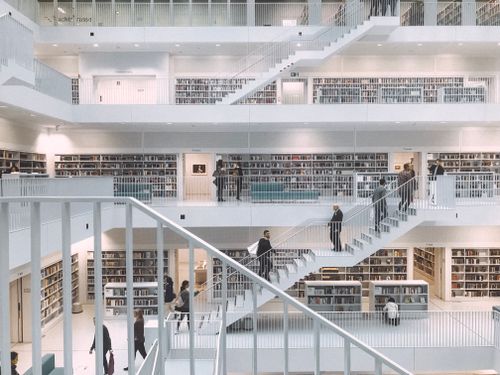 Free Spacious and minimalist design of the Stuttgart City Library showcasing multiple levels of books and people. Stock Photo