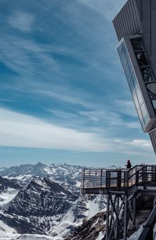 Snowy mountain landscape with a modern viewing platform offering a stunning view.