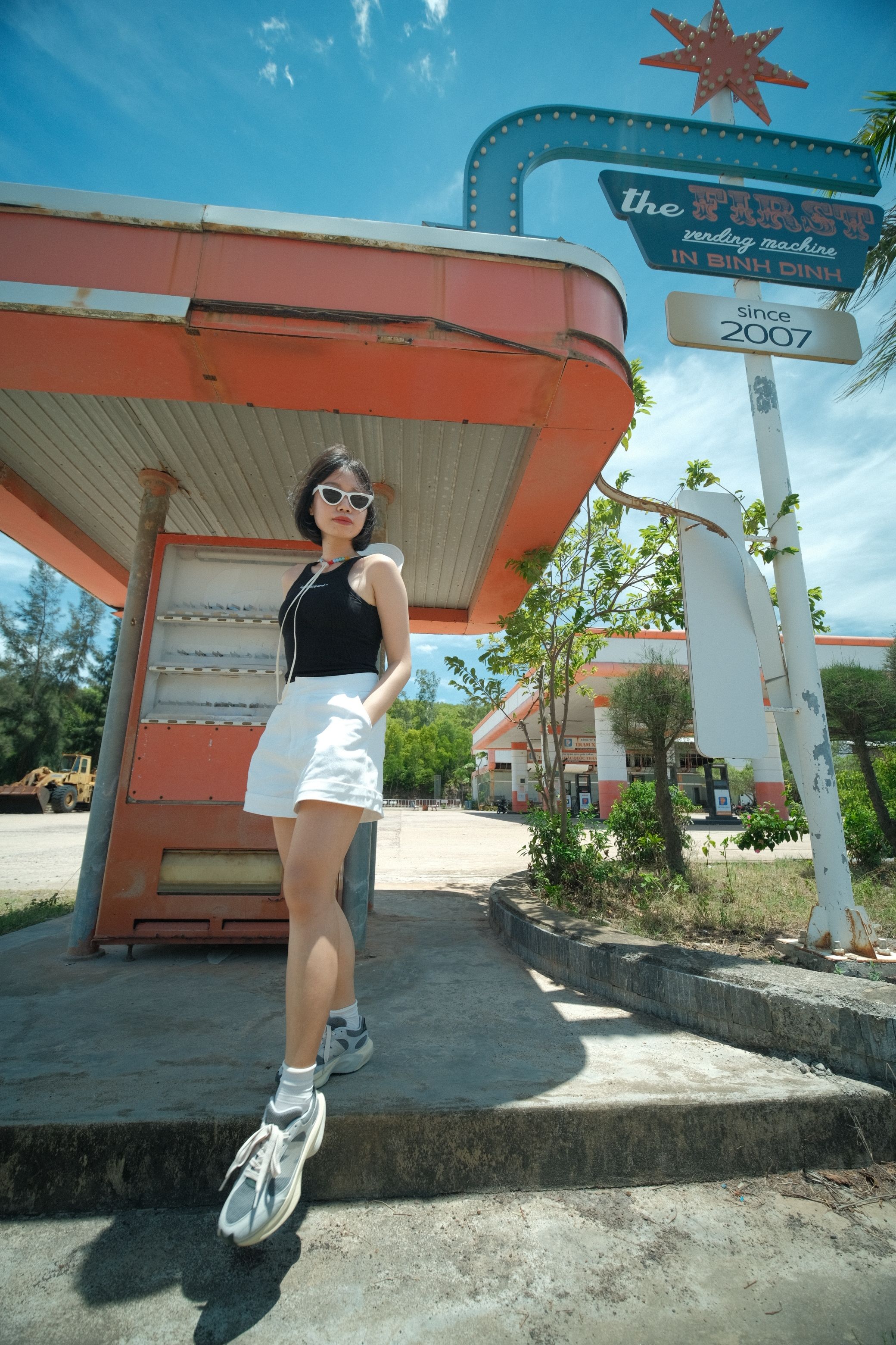 Stylish Woman Posing at Retro Gas Station