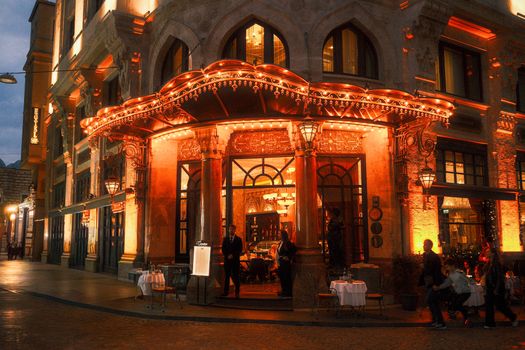 Charming vintage restaurant with warm lights and intricate architecture at night.