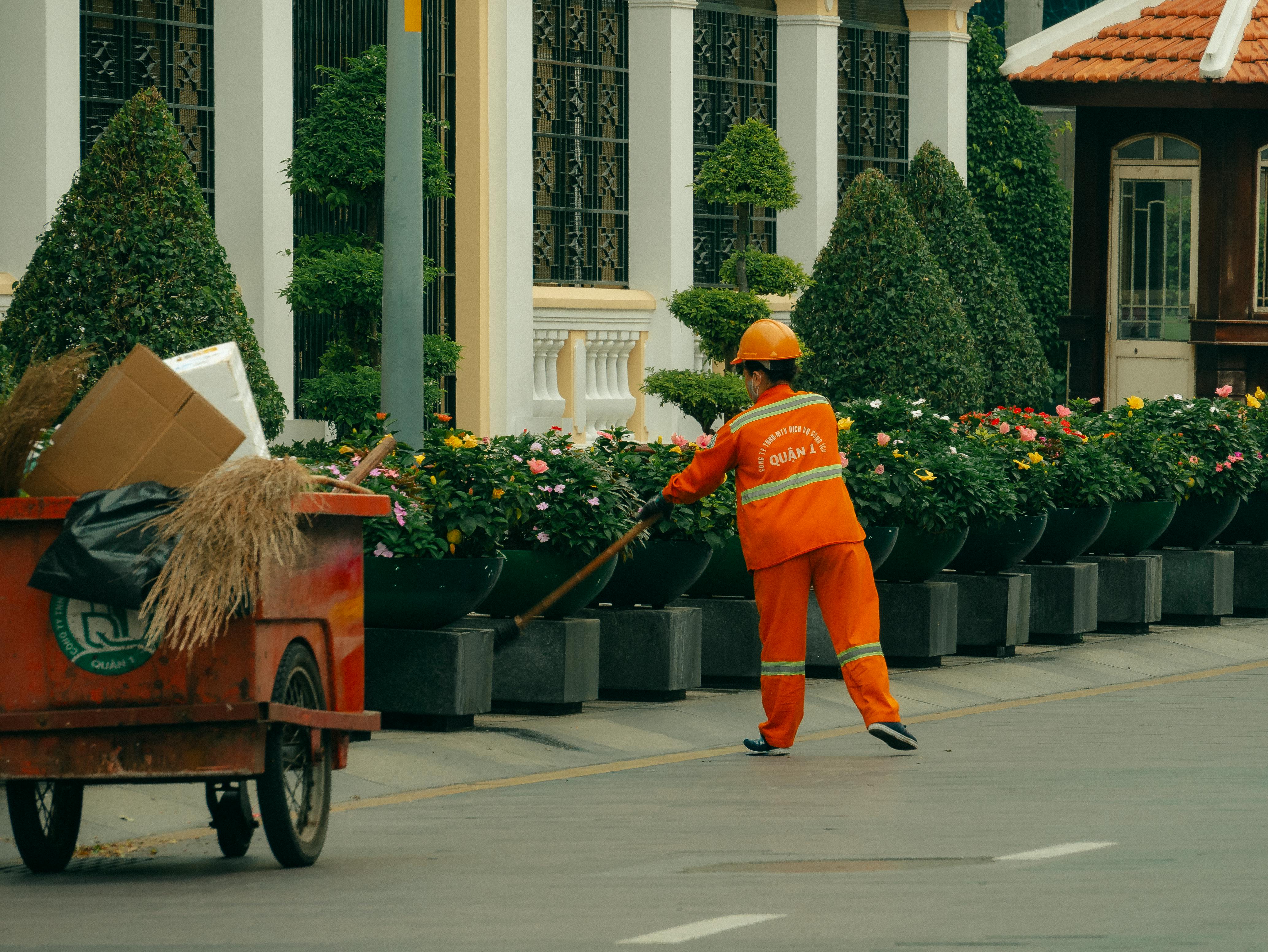 Employé d’entretien paysager travaillant sur des massifs fleuris en ville, évoquant la visibilité locale sur Google Maps