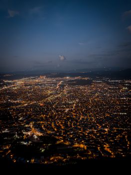 Aerial view of a brightly lit cityscape at night, showcasing urban lights.