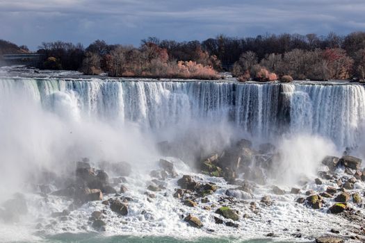Stunning view of Niagara Falls surrounded by autumn foliage, showcasing its natural beauty.
