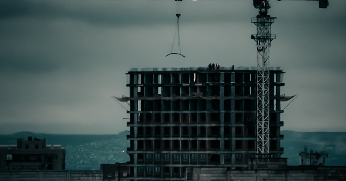 Photo by Bulat369 🌙 Dramatic city skyline featuring a construction site and crane at dusk.