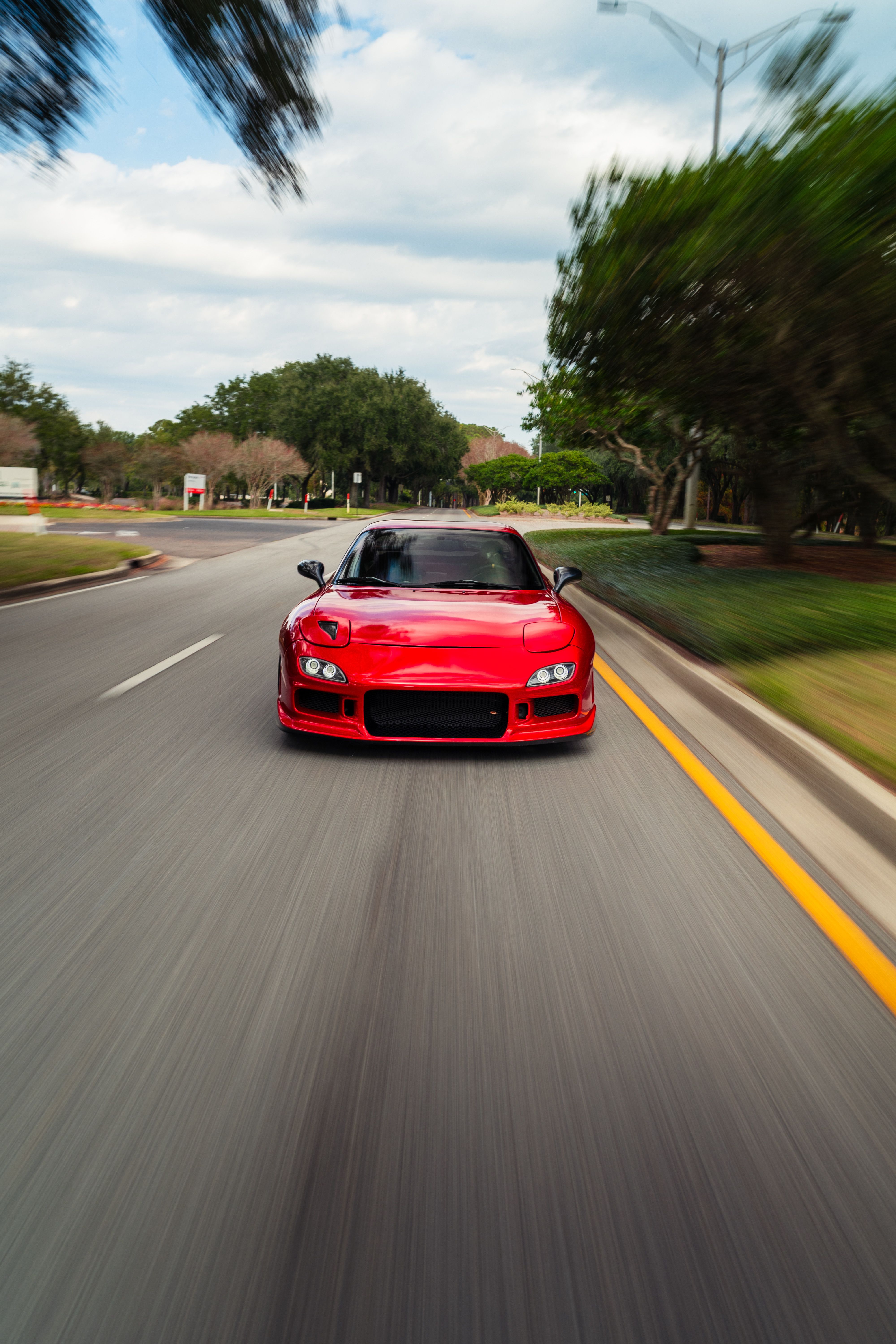 Red Sports Car Speeding on a Scenic Road · Free Stock Photo