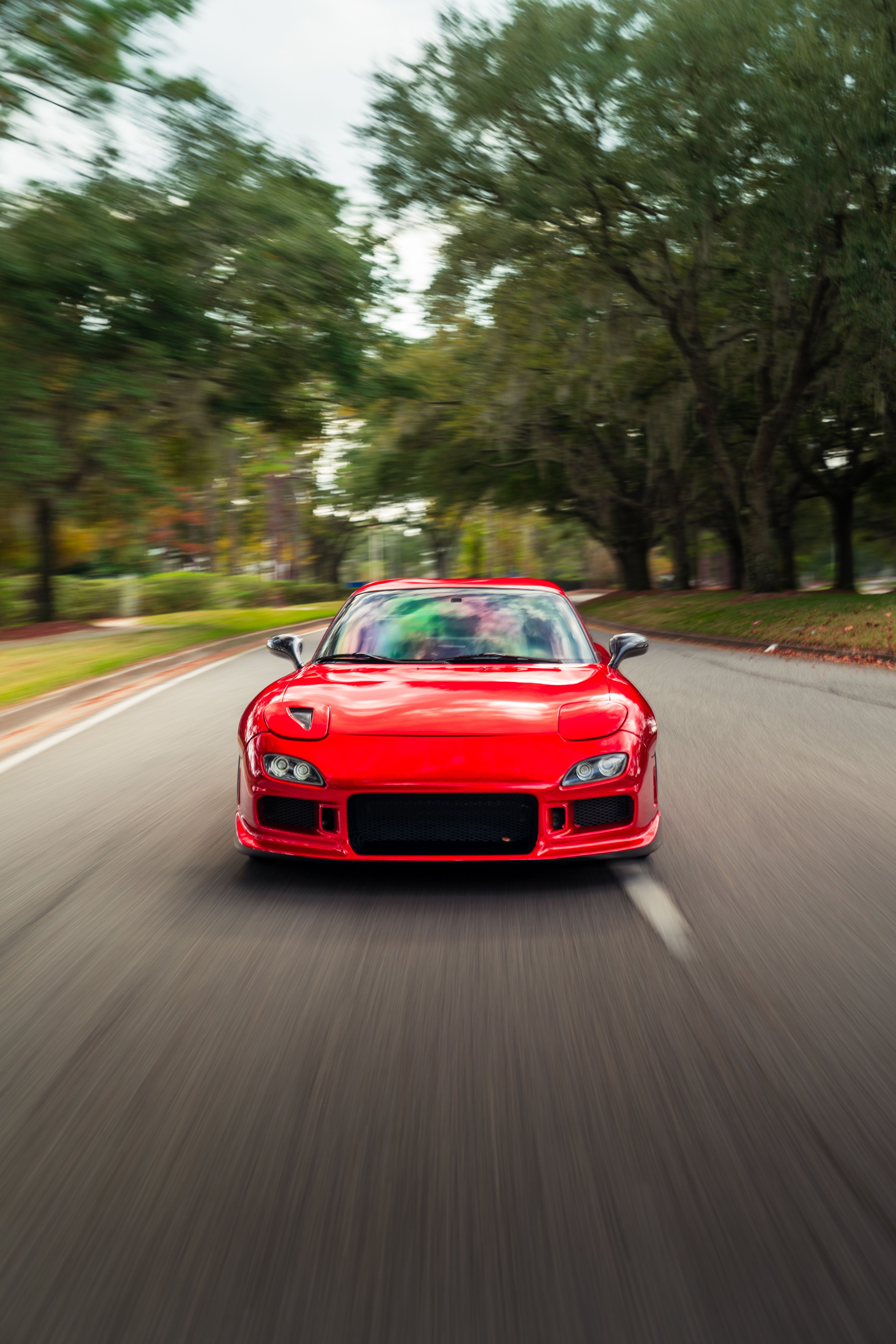 Dynamic Red Sports Car on Scenic Road · Free Stock Photo