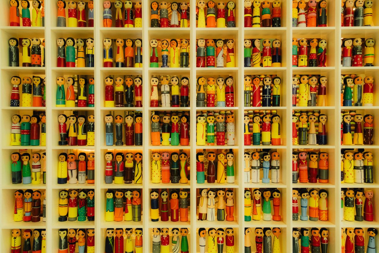 vibrant wooden figurines neatly arranged in a grid like display showca