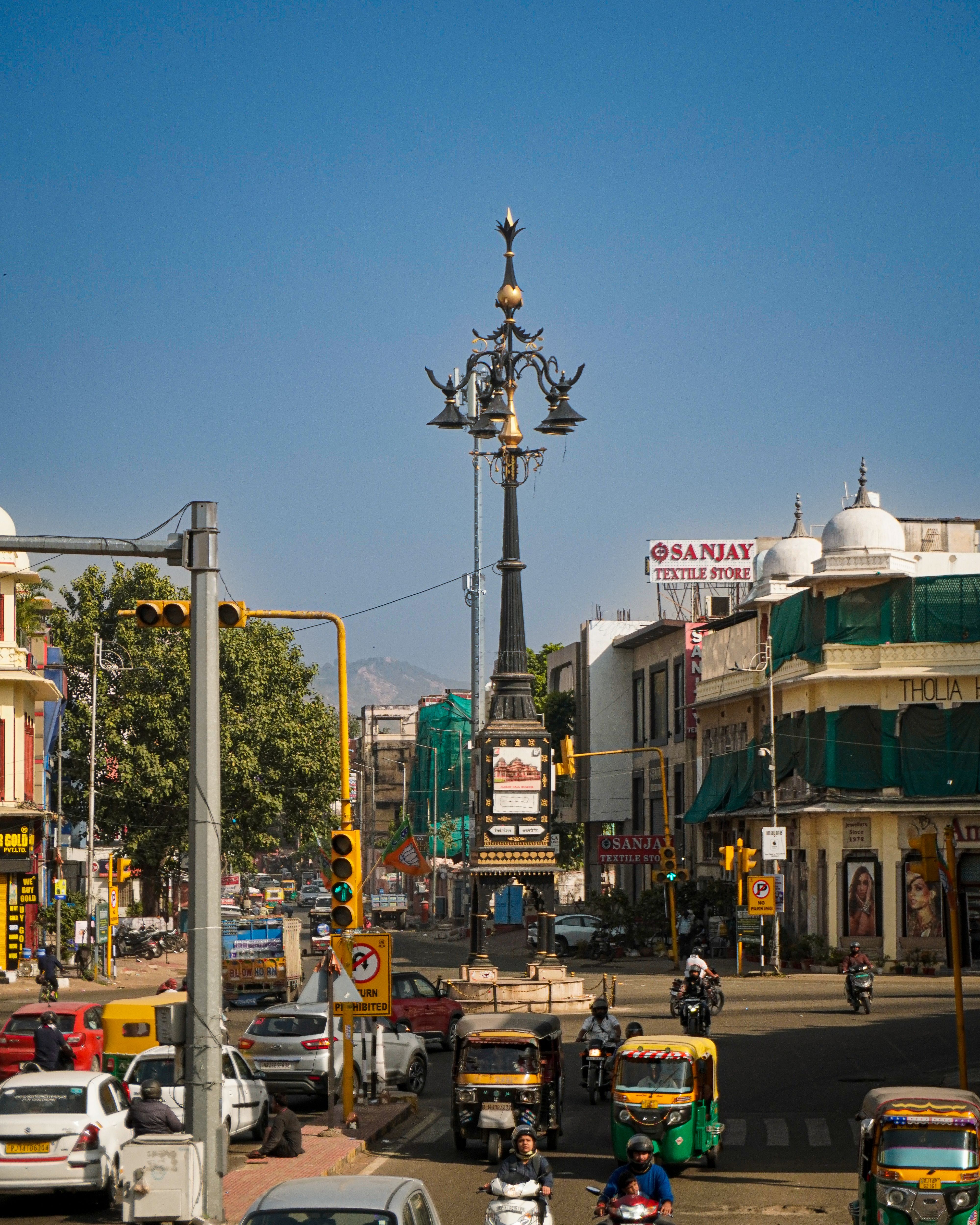 Vibrant daytime view of a busy street in Jaipur, India, showcasing local architecture and traffic.
