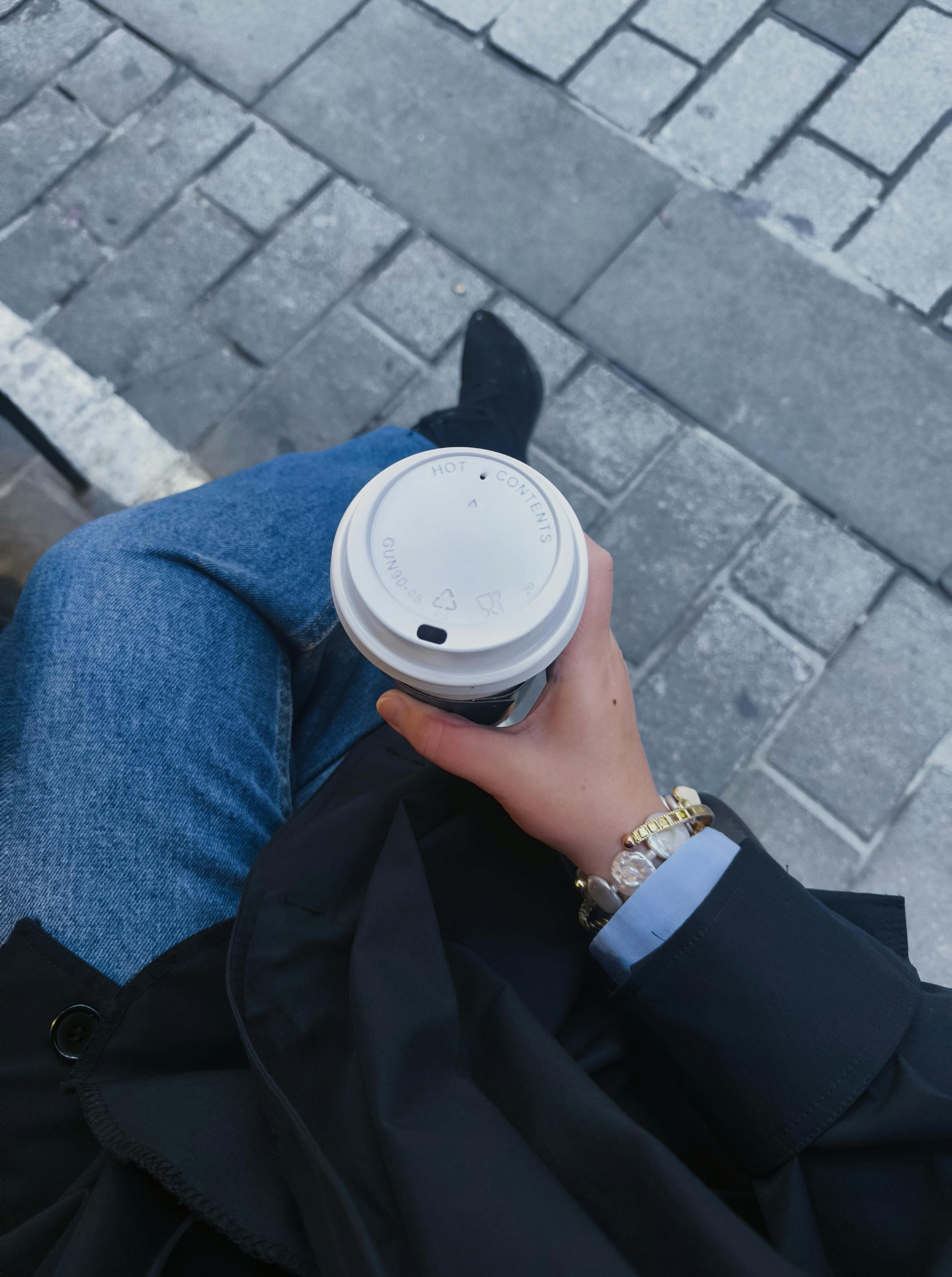 grátis Uma pessoa tomando café ao ar livre em Istambul, vestindo jeans casuais e joias. Foto profissional