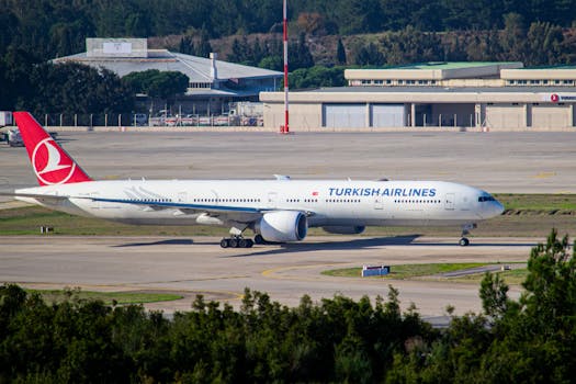 Turkish Airlines Boeing 777 taxiing on the runway at a sunny airport day.