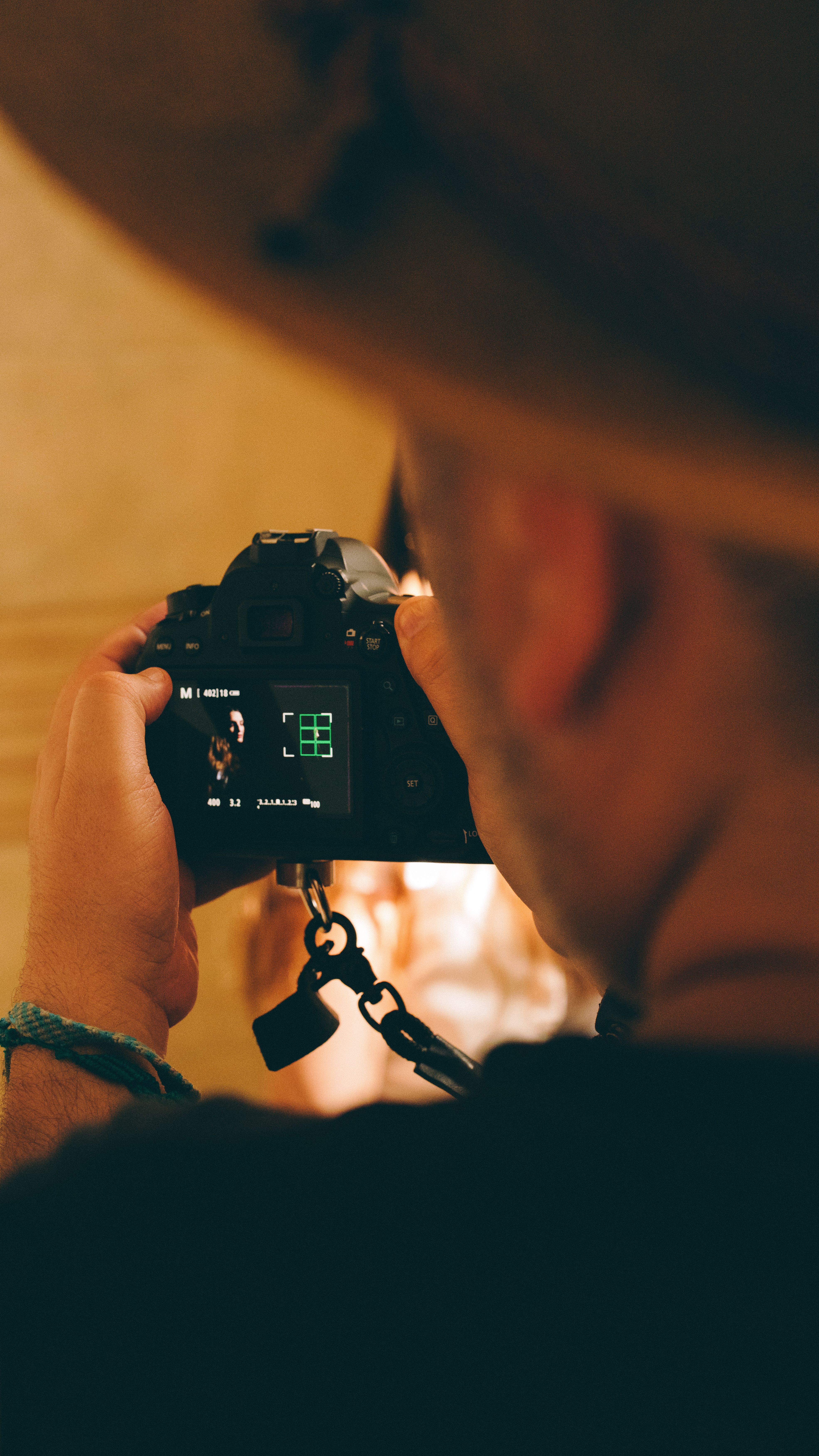 Close-up of a photographer taking a portrait inside with soft lighting.