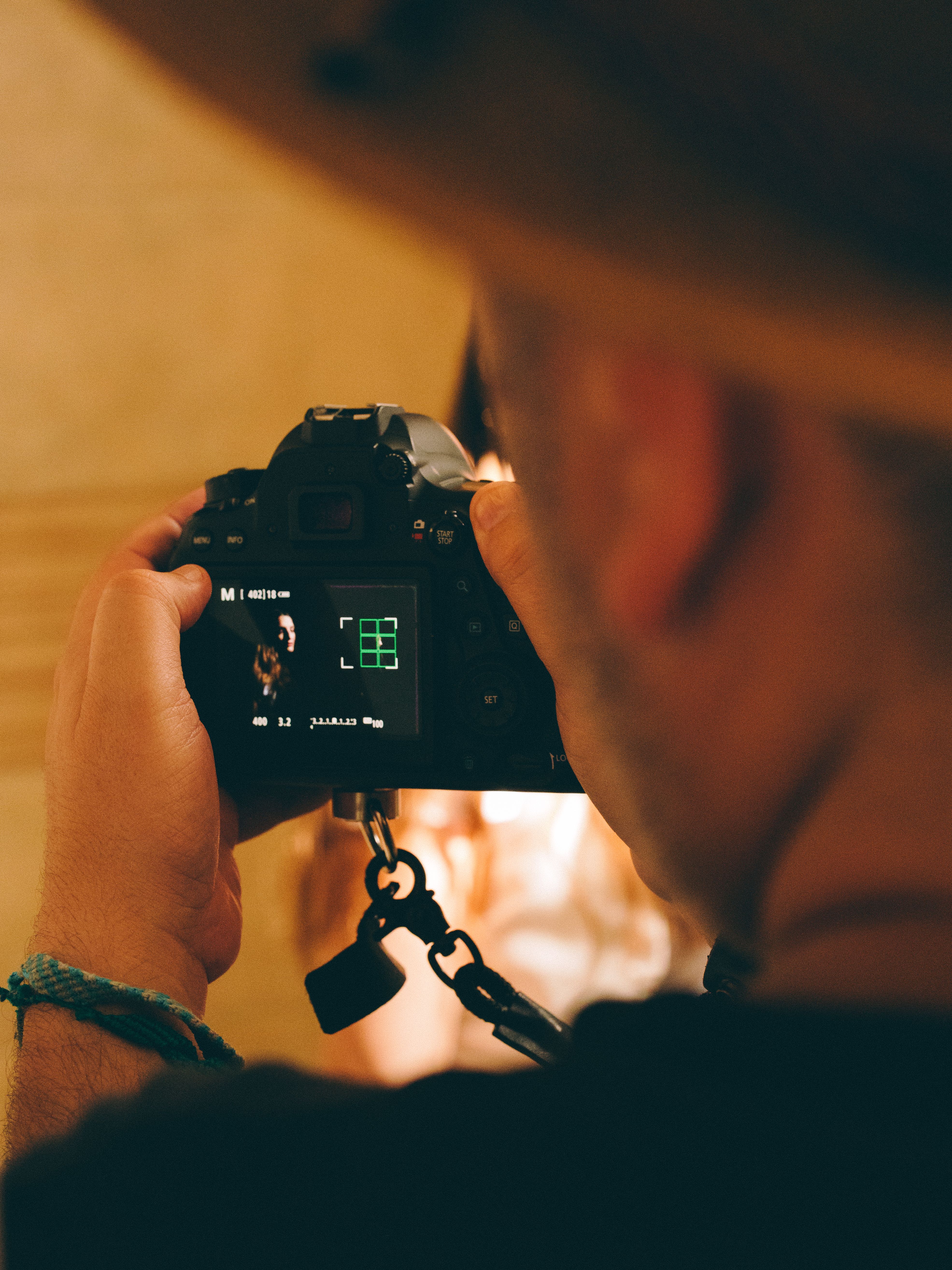 Photographer taking a picture indoors focusing on details with camera viewfinder.