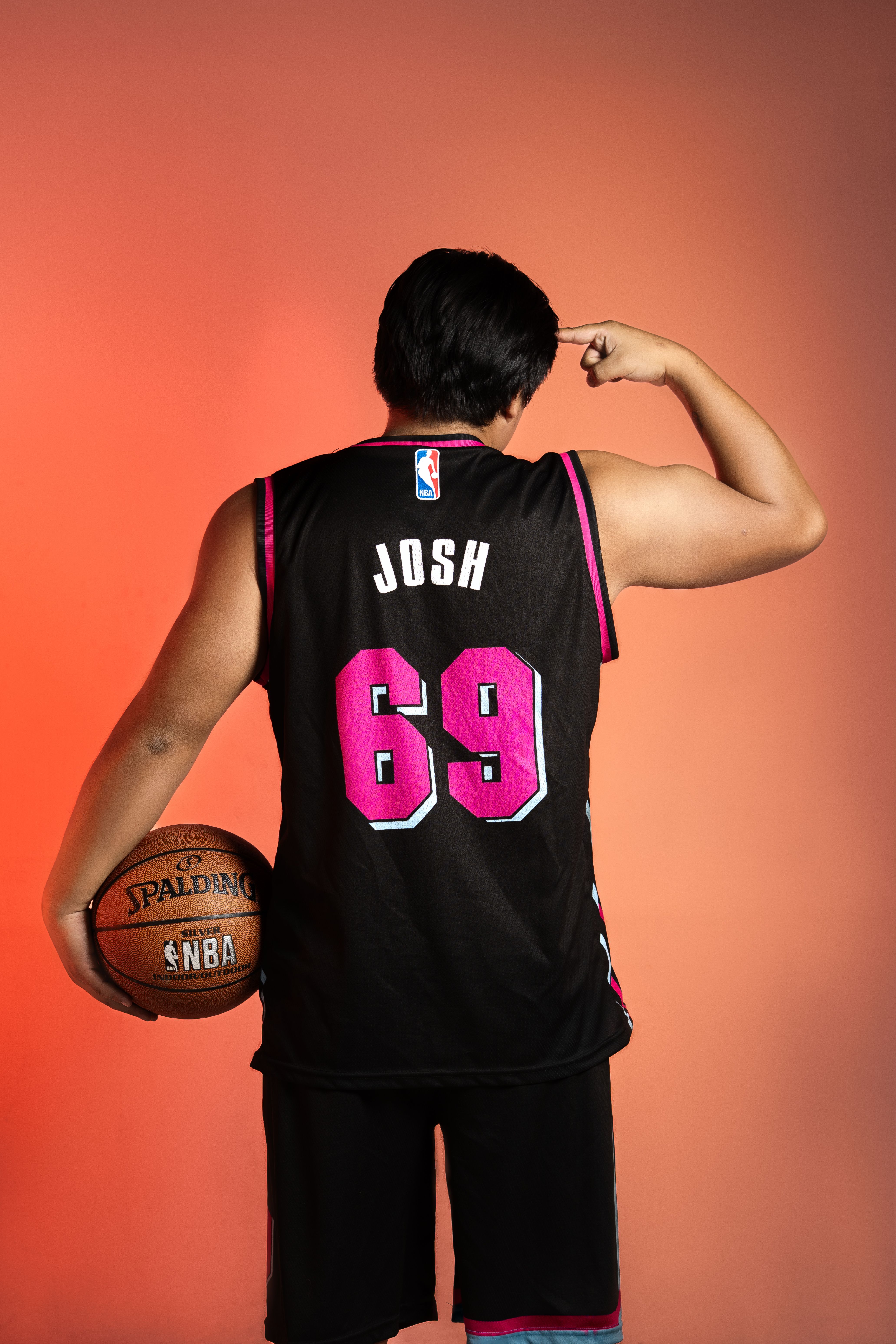 Back view of a basketball player holding a ball, featuring a custom jersey.