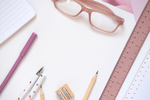 Free A neatly arranged flat lay of office supplies including pink glasses, ideal for creative projects. Stock Photo