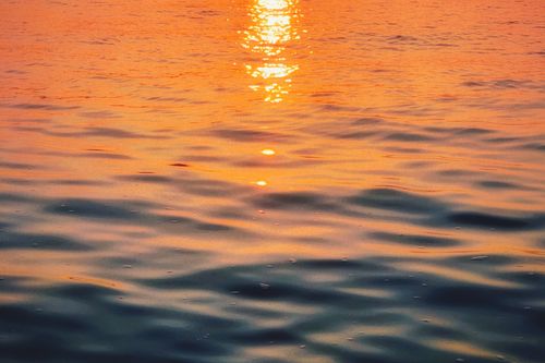 Free Golden sunset reflection on calm ocean waves creates a serene, picturesque scene. Stock Photo