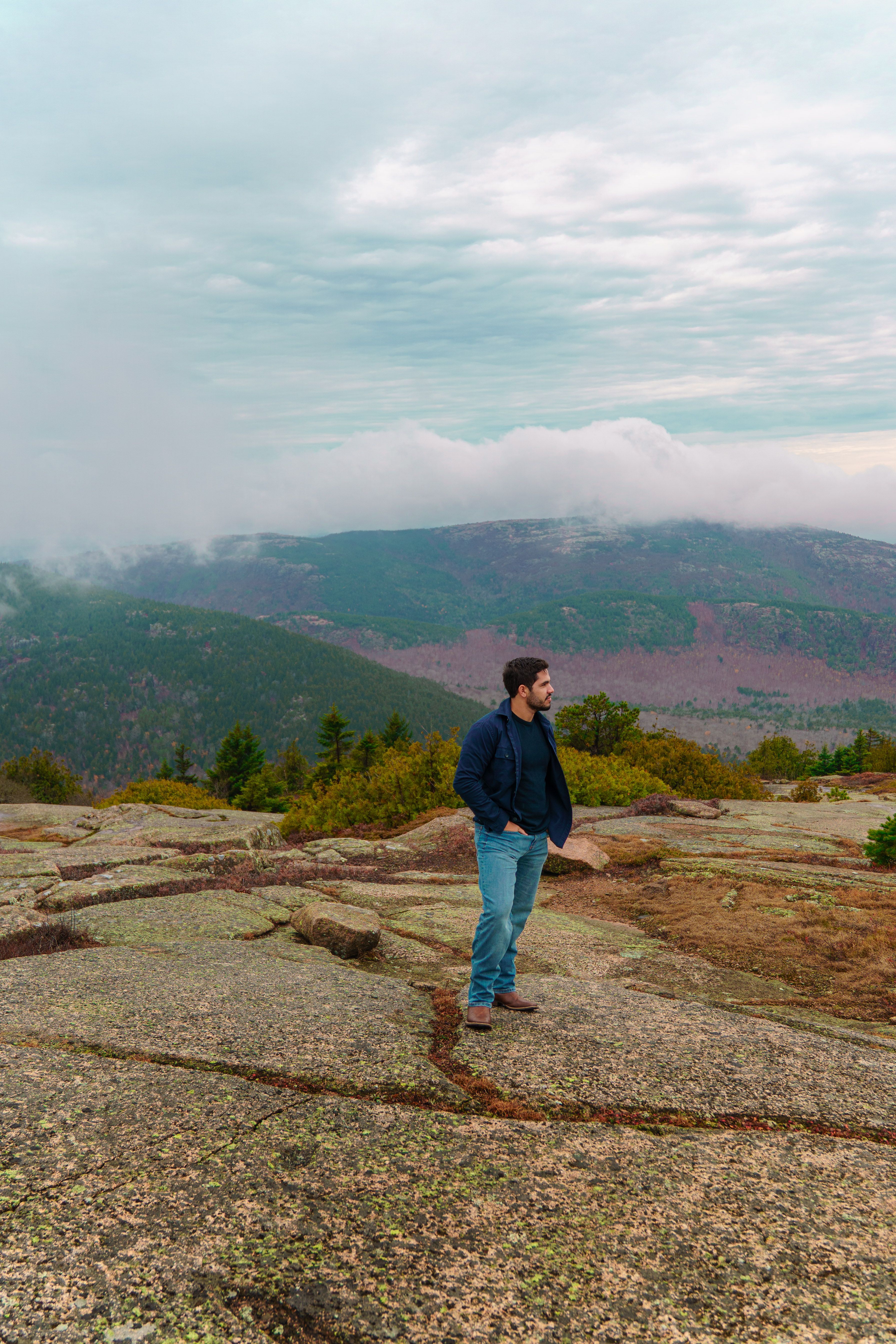 Man Standing on Rocky Mountain Overlooking Scenic View · Free Stock Photo