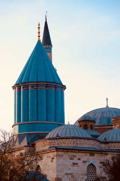 Free A vibrant view of the Mevlana Museum's unique architecture in Konya, Turkey, with its distinct turquoise dome. Stock Photo