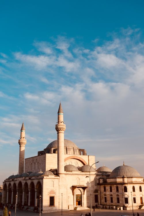 Free Beautiful Ottoman mosque with minarets under a clear blue sky, captured at sunrise. Stock Photo