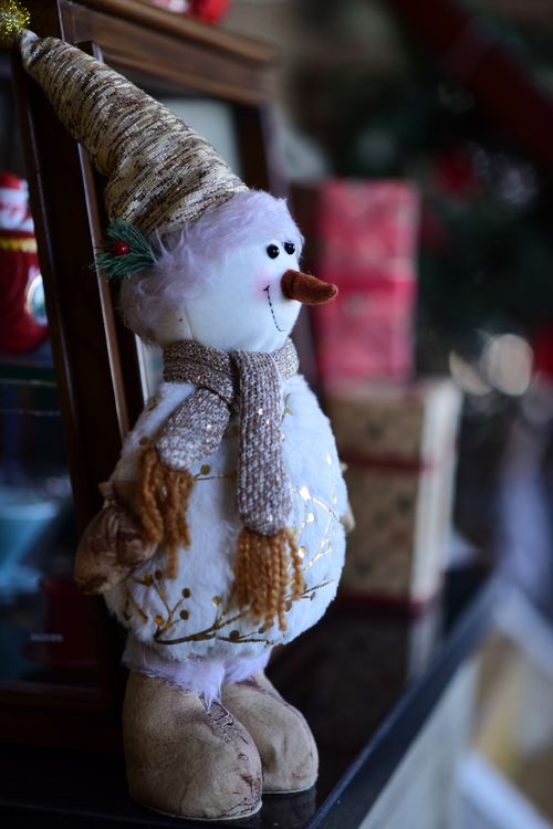 Free Cute snowman decoration with gifts, capturing a cozy, festive atmosphere. Stock Photo