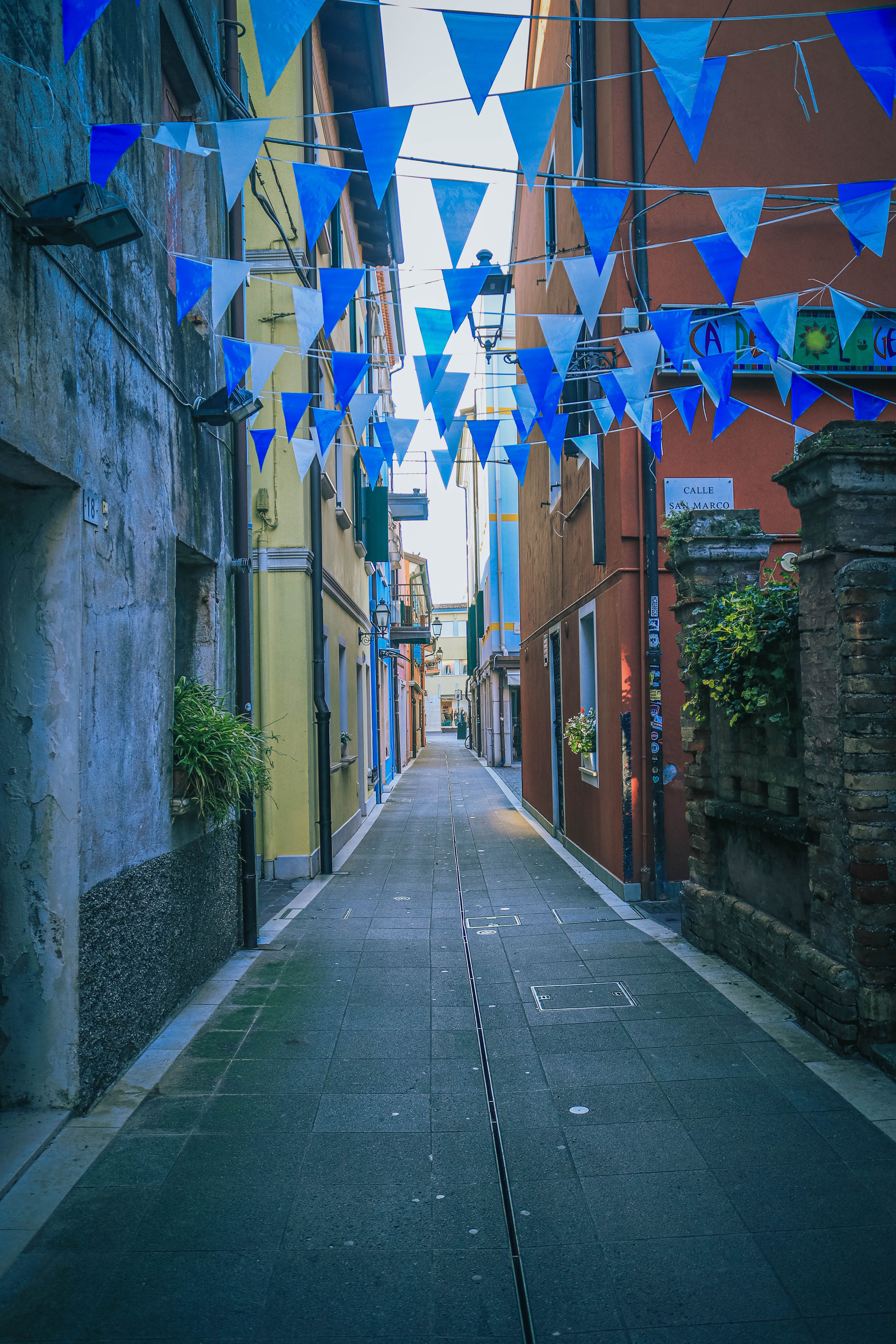 Charming European Alley with Festive Flags · Free Stock Photo