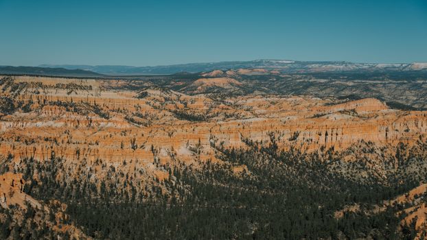A stunning aerial view of Bryce Canyon's dramatic red rock formations and valleys under a clear sky.