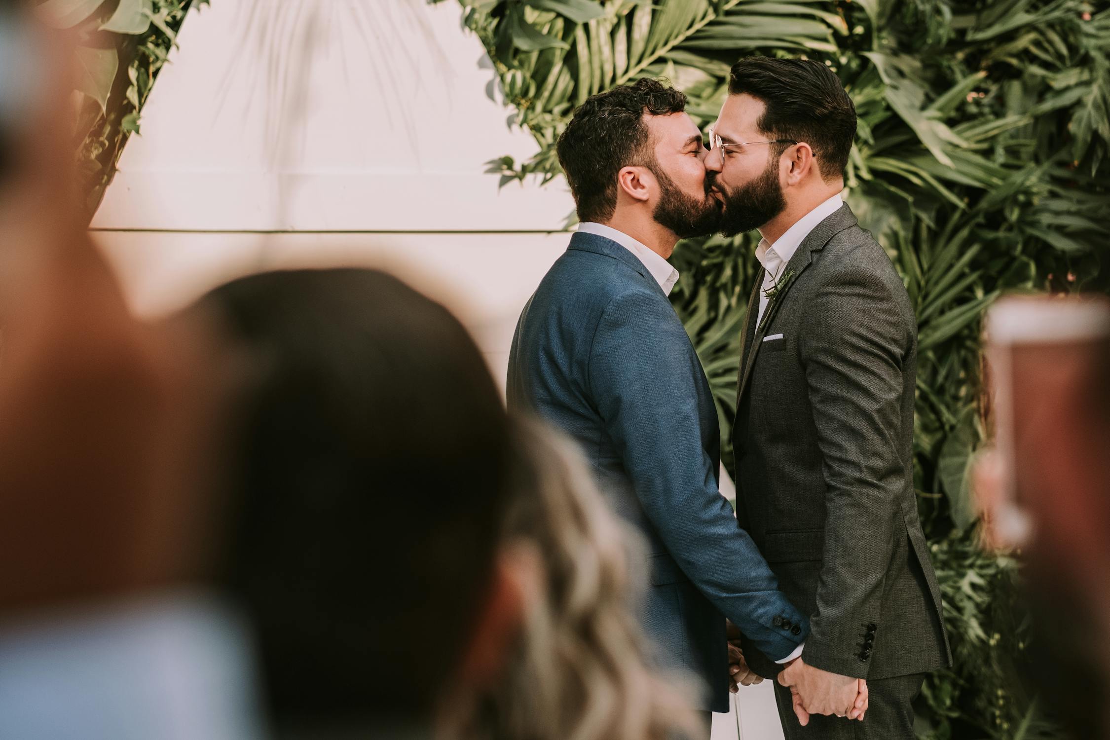 newly married couple kissing at rooftop wedding reception