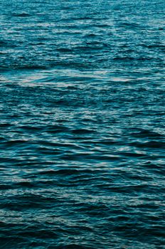 Tranquil deep blue ocean water with gentle waves creating a peaceful scene.