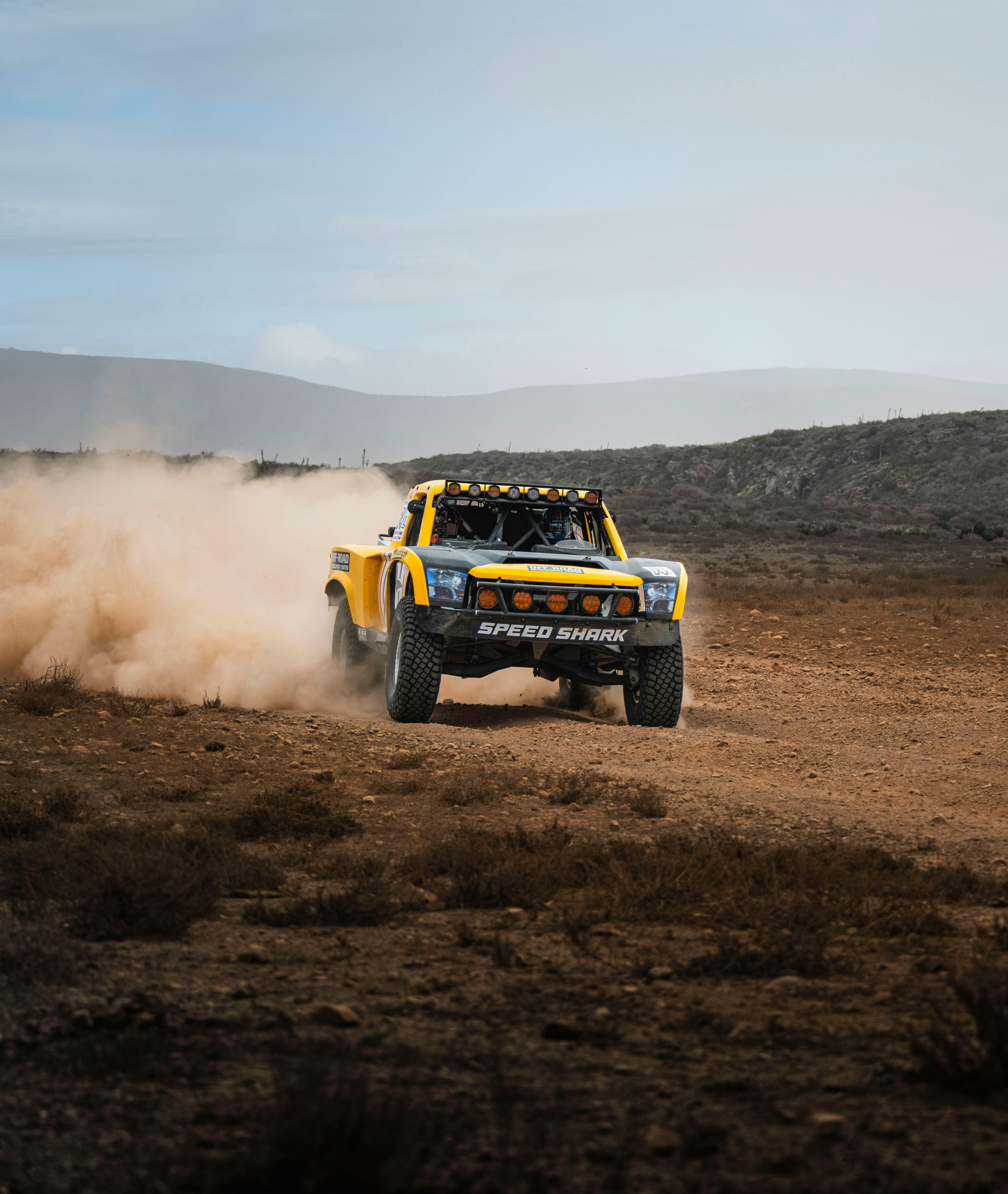 Trophy truck speeds through Baja California desert, kicking up dust during an exciting off-road race.