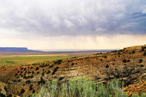 Free Stunning view of a desert landscape with dramatic clouds and distant rain. Stock Photo