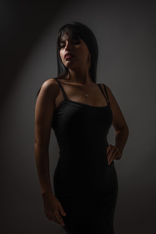 Free Portrait of an elegant woman in black dress with mysterious lighting. Stock Photo
